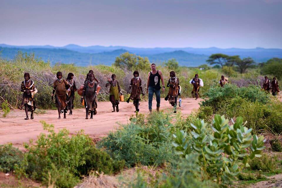 William posing with smiling tribal members